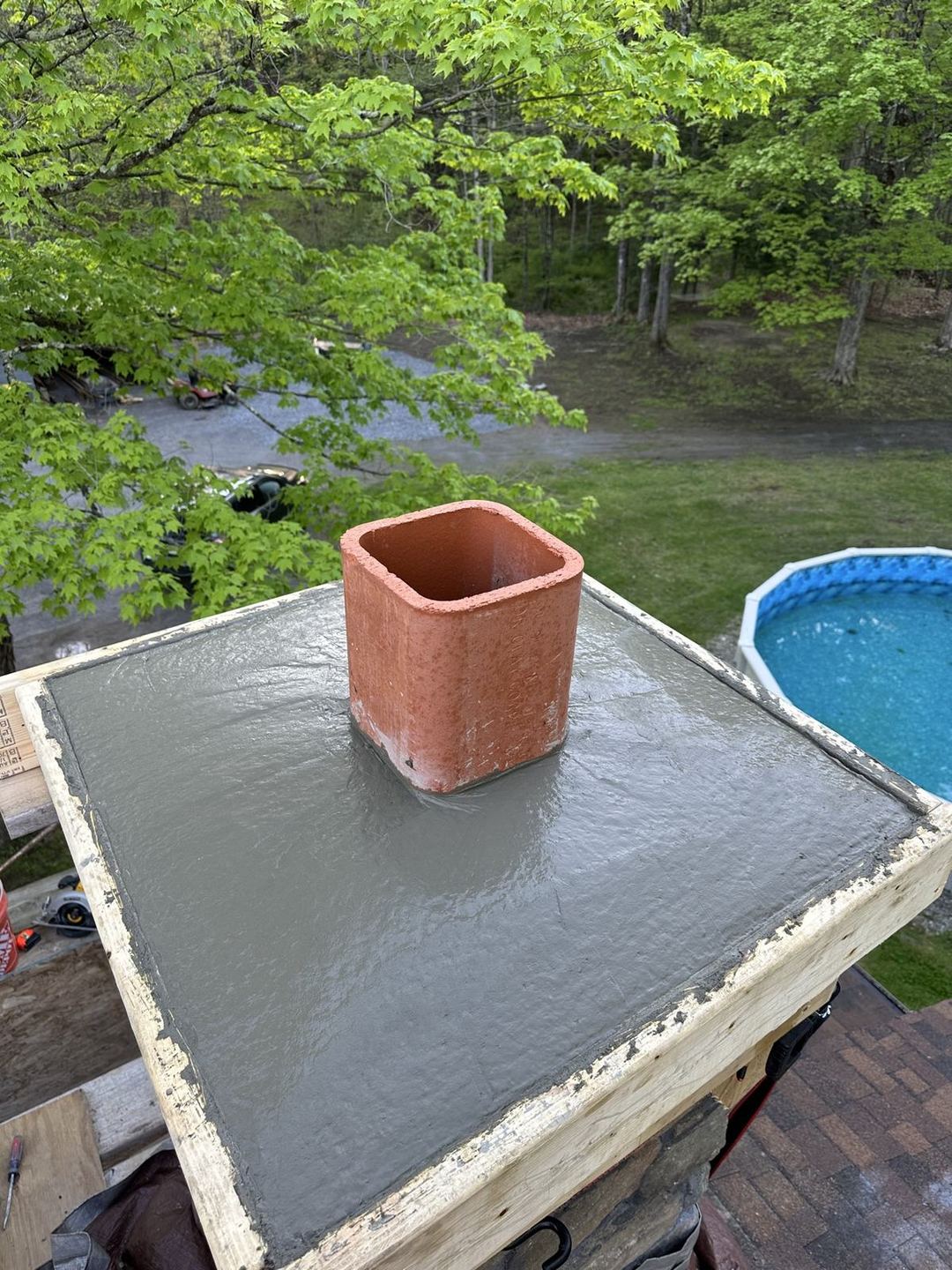 Fresh-poured concrete chimney cap with a new clay flue