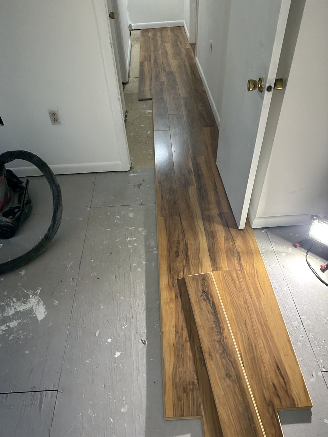 Luxury vinyl plank flooring being installed in a hallway