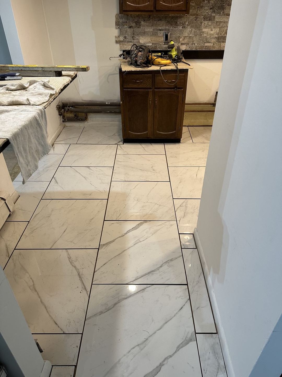Tile kitchen floor with a stacked-stone backsplash